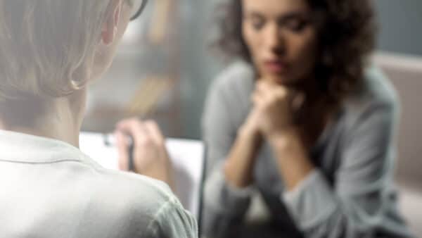 Young depressed woman talking to lady psychologist during sessio