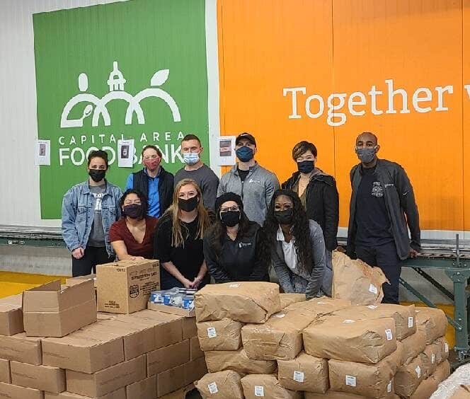 Group of volunteers packing food supplies at Aptive Resources food bank.