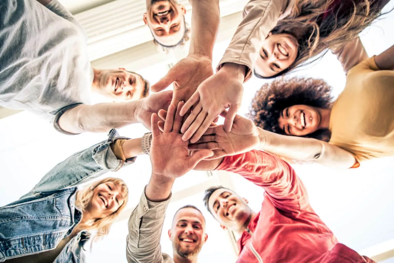 Young happy people stacking hands together outcoor   Community o