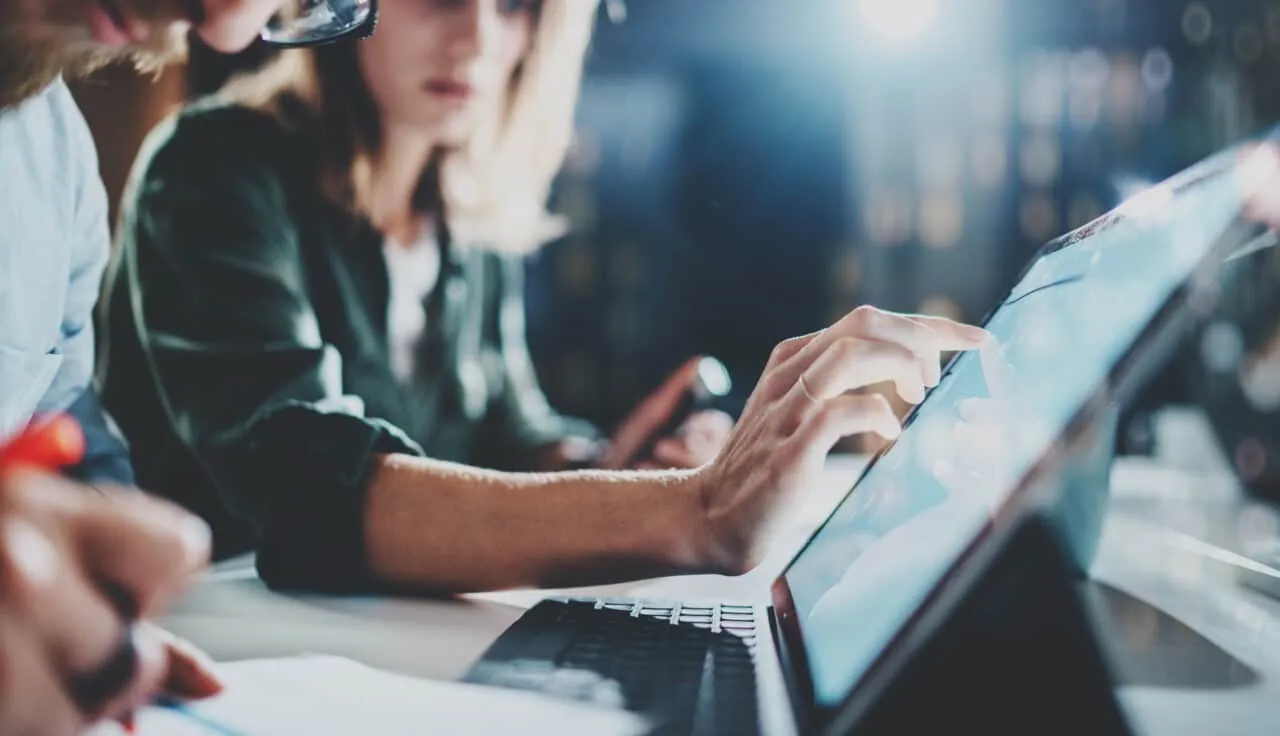 Woman pointing on digital tablet screen at night office .Horizontal.Blurred background.Flares.