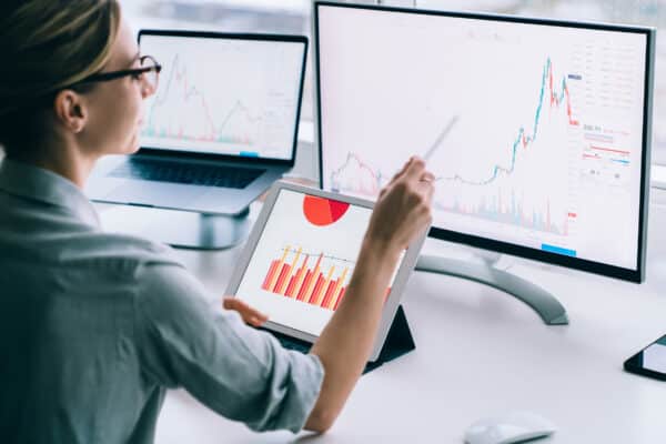 Crop businesswoman researching charts on computer