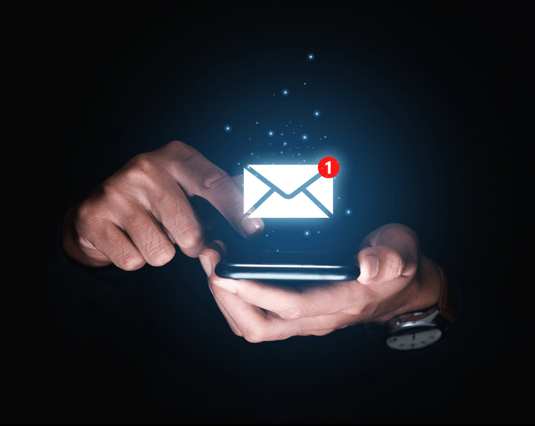 Person using smartphone with email notification icon and spark effects.