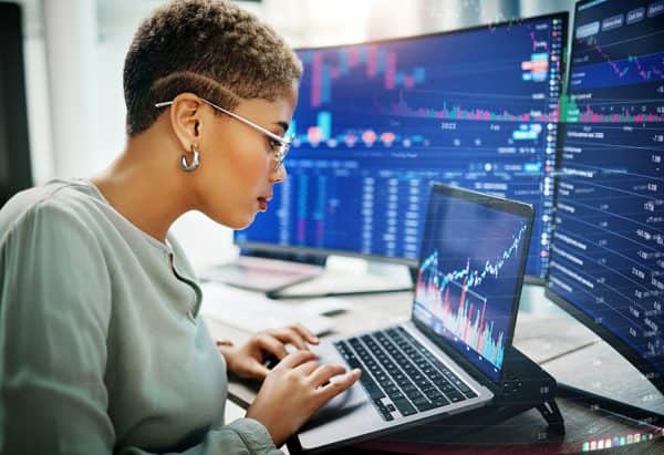 Laptop, investment graphs and business woman reading IPO analytics, financial bank chart or accounting value, info or stocks. Trade price, admin data analysis and profile of broker review statistics
