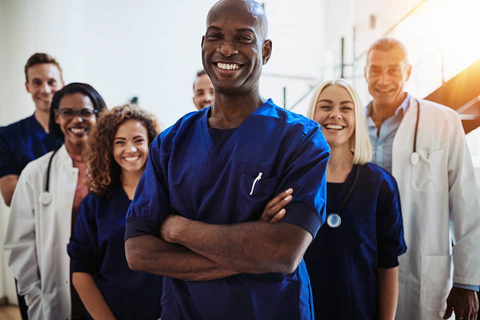 Diverse healthcare team smiling in a hospital setting.