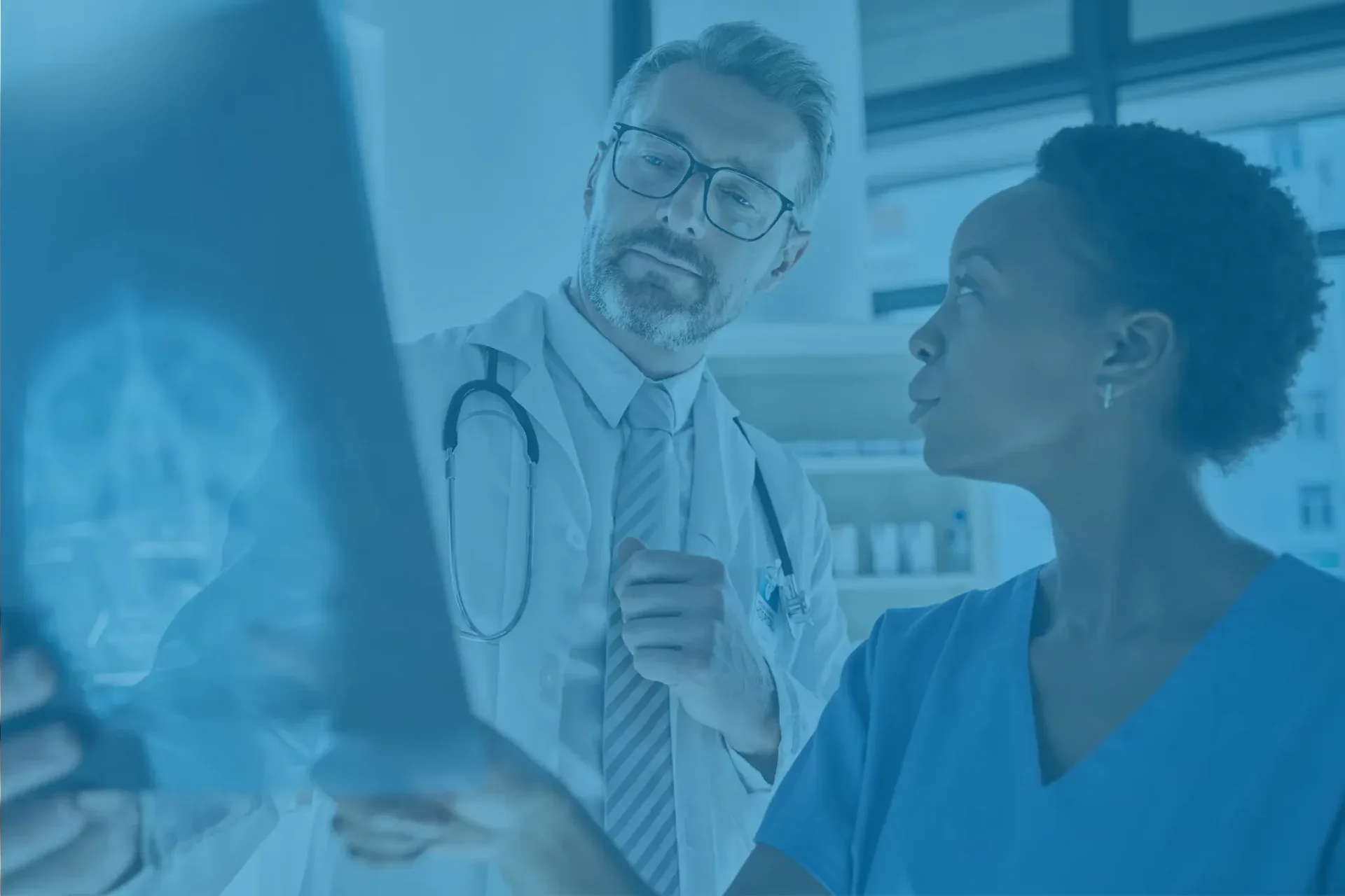 Medical professionals discussing patient X ray in a clinical setting.