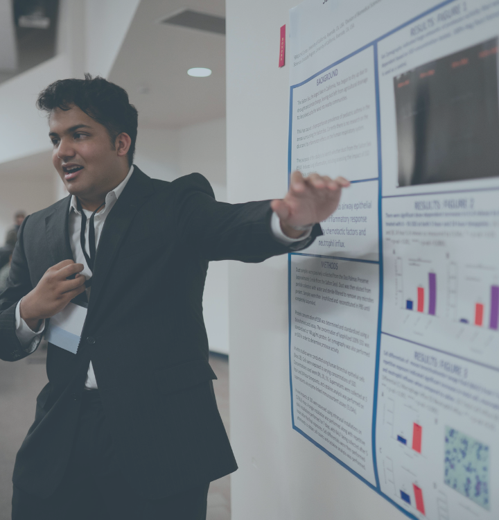 Young professional presenting research data on a poster at a conference.