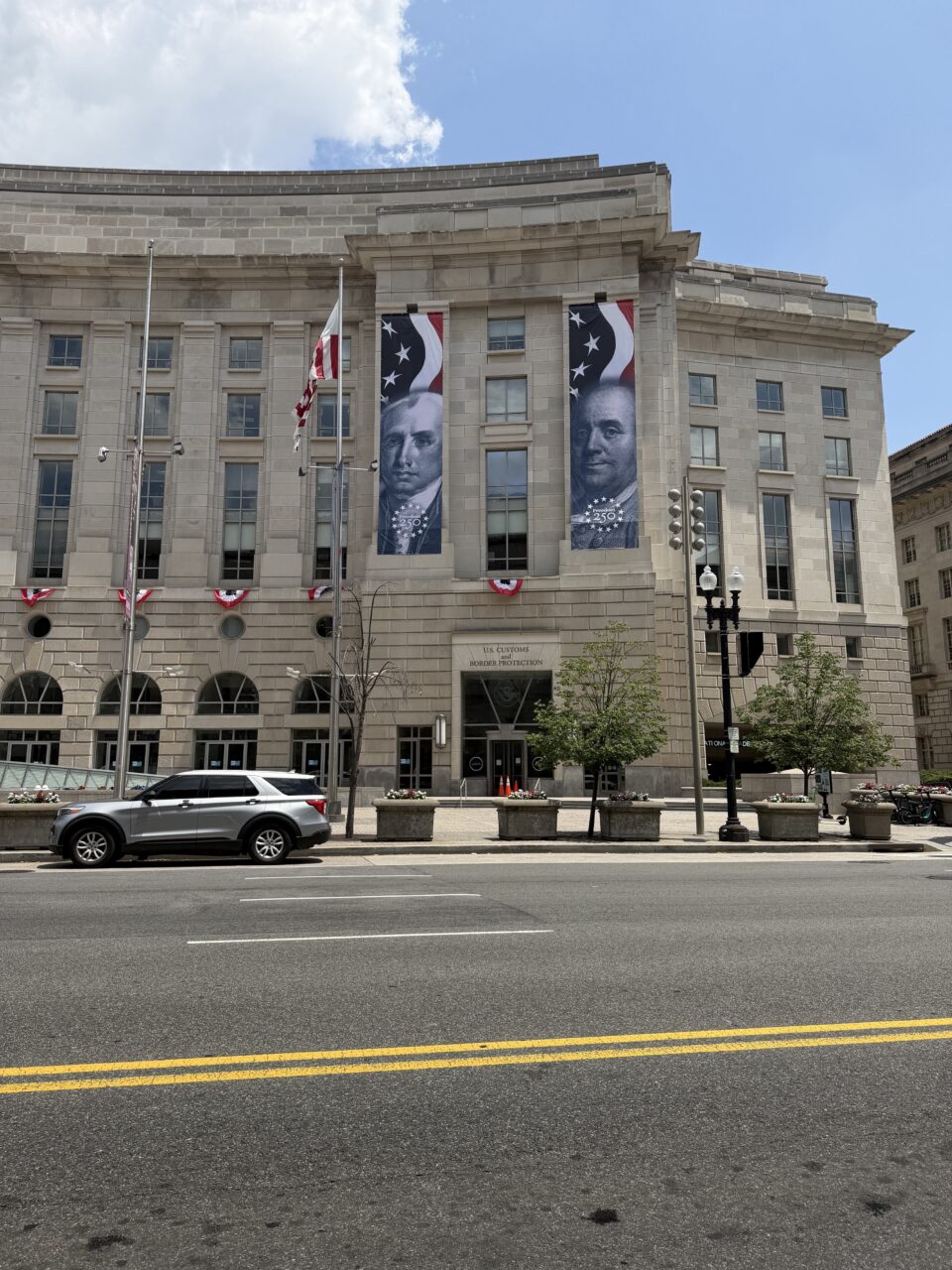 Historic building decorated with American flags and banners for 250th Independence Day celebration.
