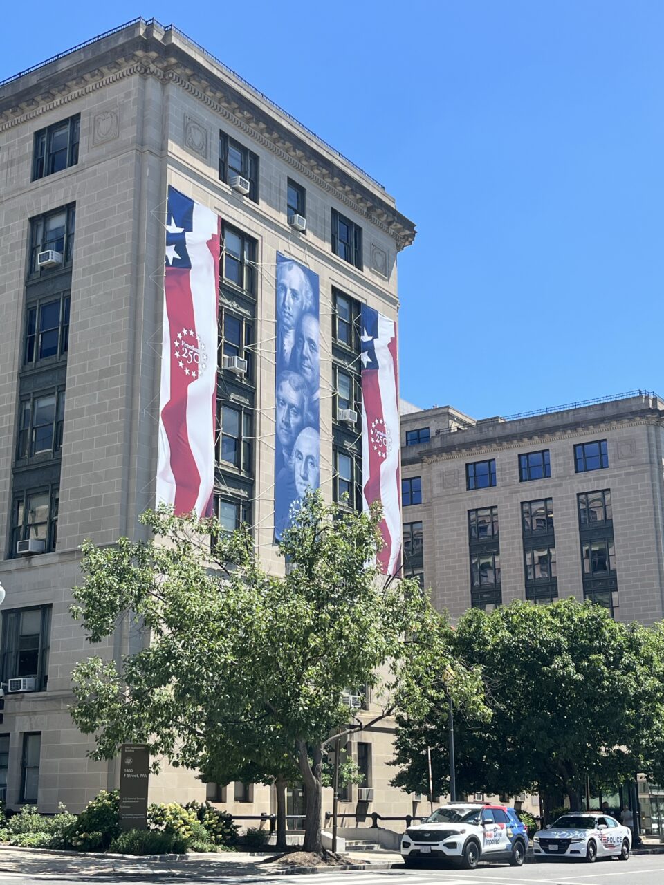 Historic building decorated with patriotic banners for America's 250th anniversary.