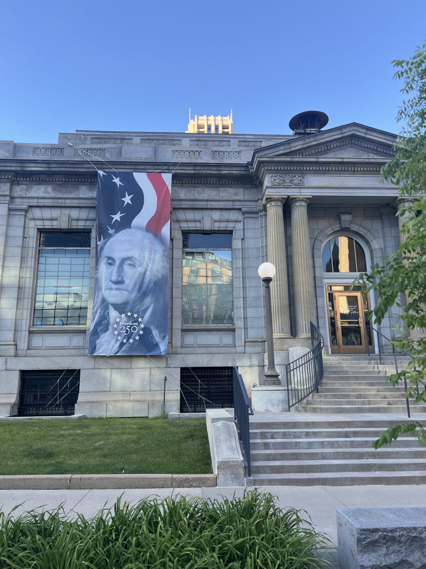 Historic government building with a large American flag banner celebrating 250 years.