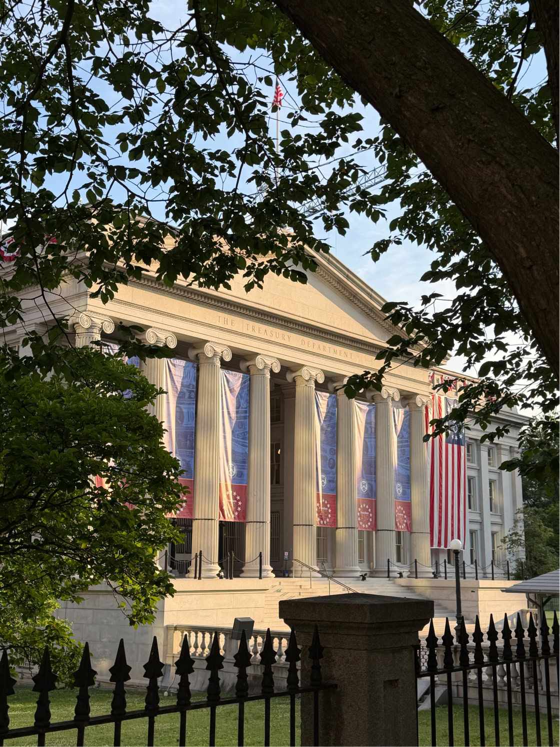 Historic building decorated with American flags for Independence Day celebration.