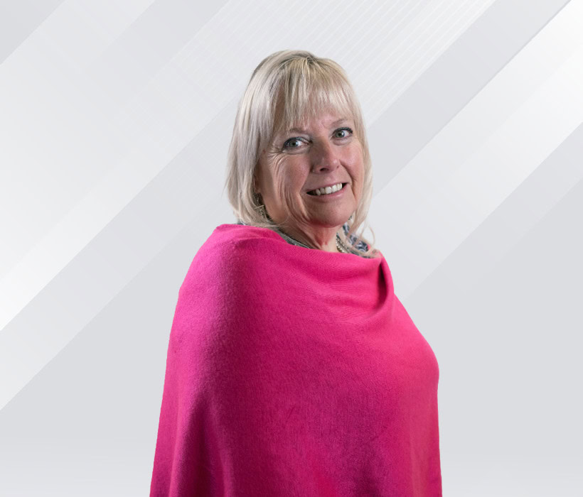 Tammy Czarnecki smiling with a pink shawl in front of a light background.